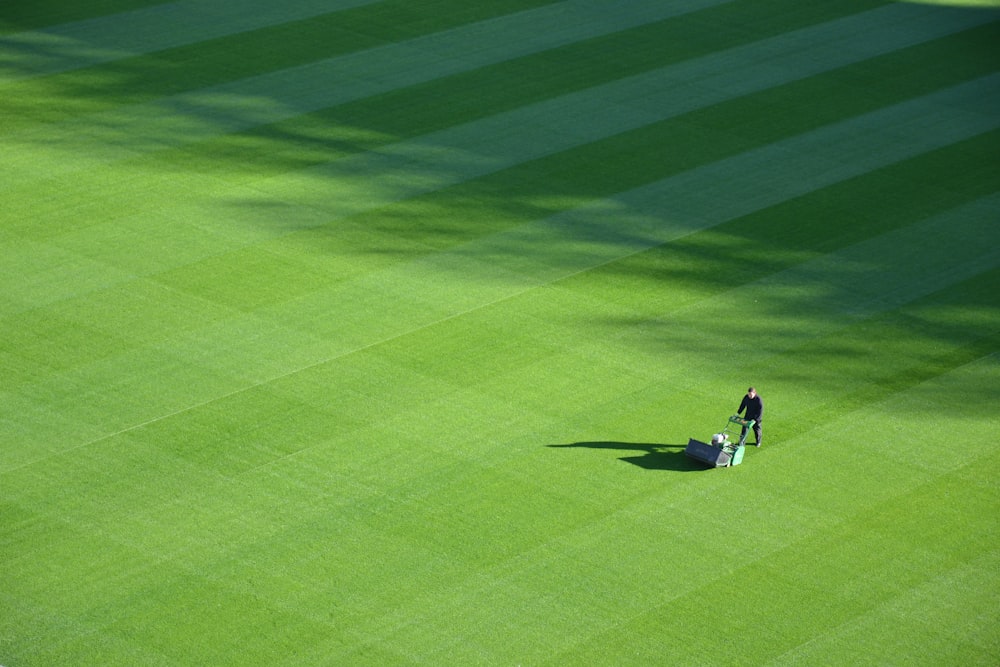 aerial photography of person trimming sports field during day