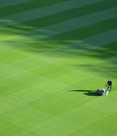 aerial photography of person trimming sports field during day