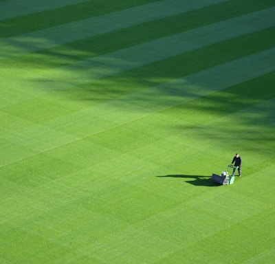 aerial photography of person trimming sports field during day