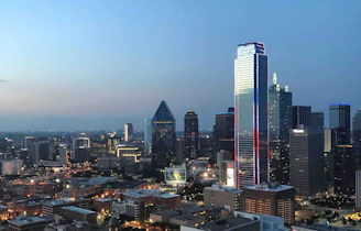 A city skyline at dusk with illuminated skyscrapers symbolizing business success and expansion.