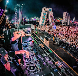 two men playing DJ controllers at night time