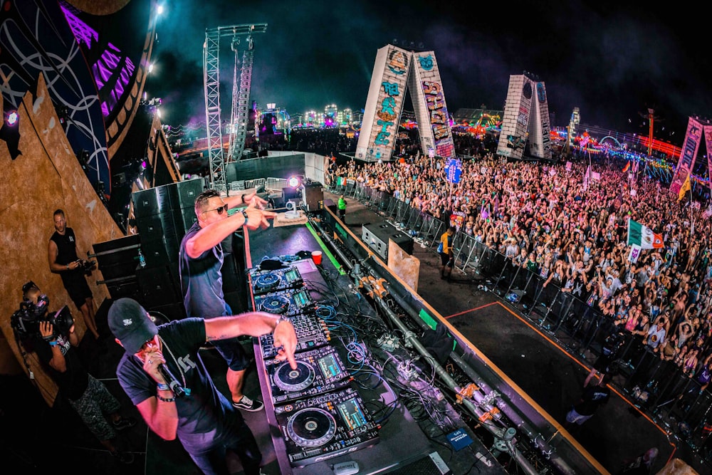 two men playing DJ controllers at night time