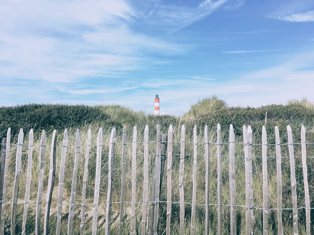foreground photography of fence overlooking lighthouse