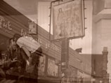 An artistic double exposure image combining street art, featuring paintings and graffiti on a building, with the scene of a couple in a casual setting. The mural includes abstract and figurative elements, while the couple appears to be sitting at an outdoor cafe or bar. The overall composition blends urban art with an intimate social moment.