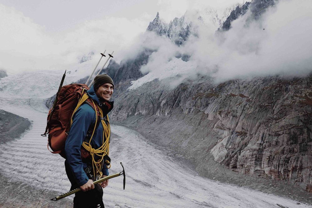 uomo in piedi vicino alla montagna durante il giorno