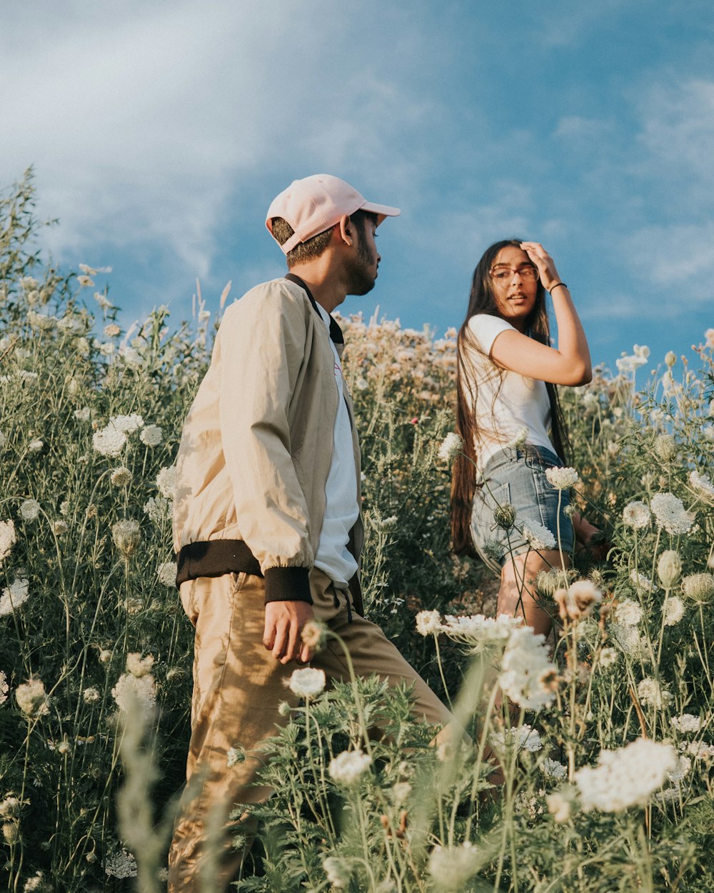 Mann und Frau klettern auf weiße wilde Karottenblumenfelder