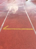 Empty running track with lane markings under blue sky