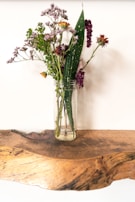 Shelly gently arranging fresh wildflowers in a rustic vase.