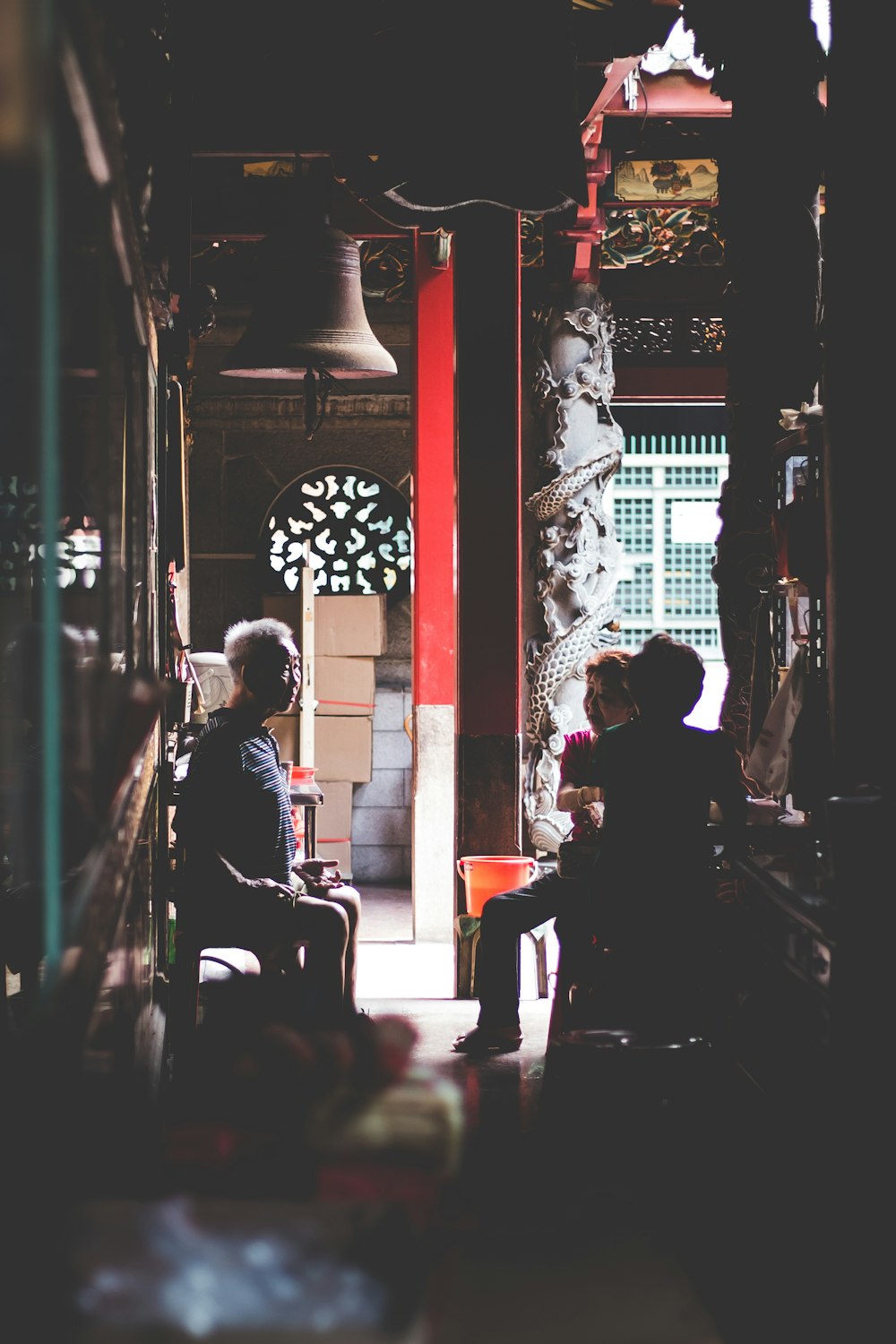 low-light photography of three people sitting on chairs indoors