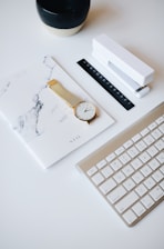 An elegant workspace featuring a notepad, pen, and a gold-accented coffee cup.