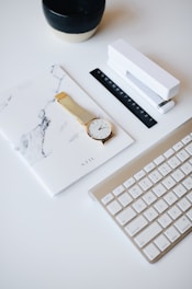 Elegant workspace with black and gold accents, featuring a sleek laptop and a certificate on a marble desk.