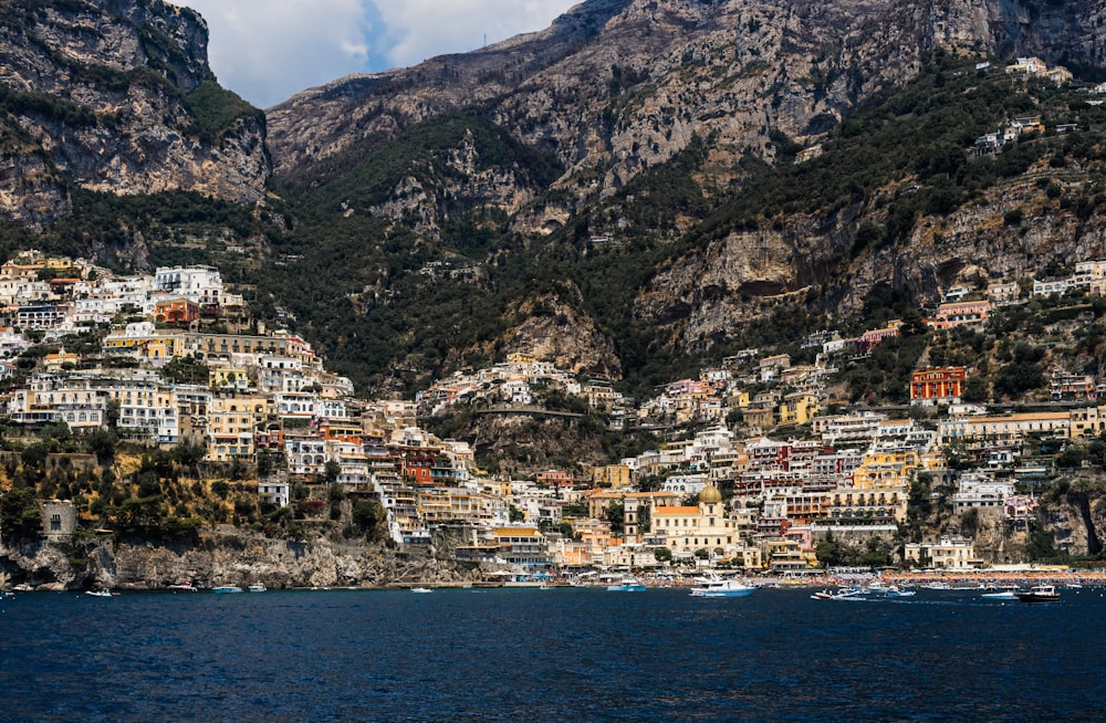 concrete buildings on mountain near body of water at daytime