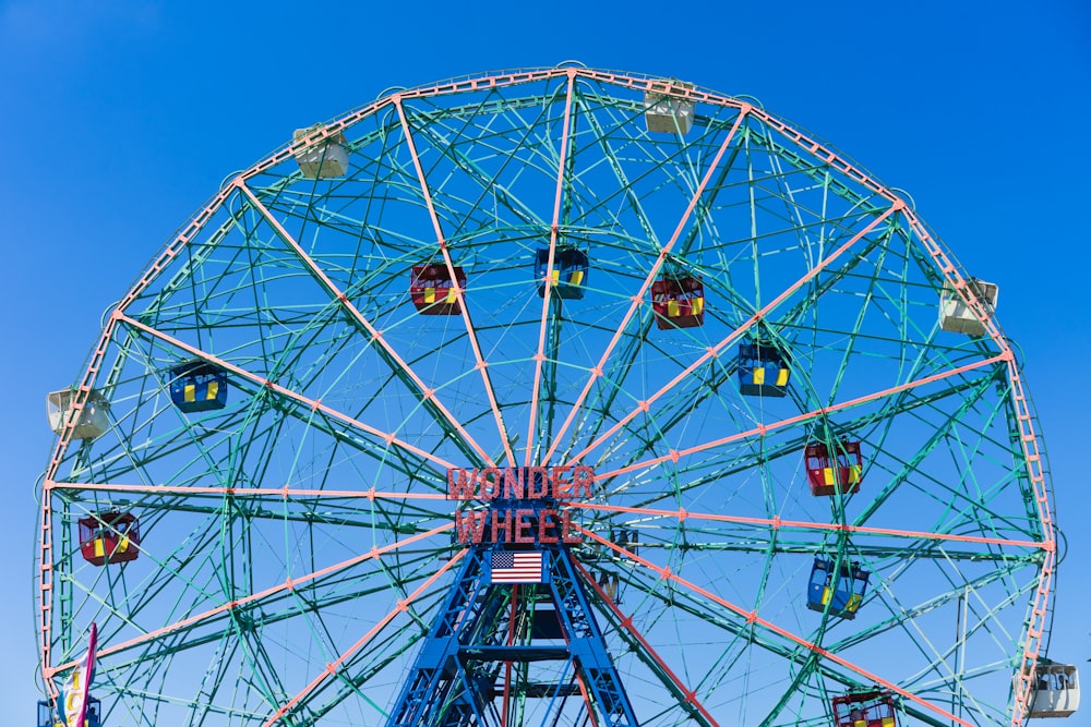 pink and white ferris wheel under blue sky at daytime