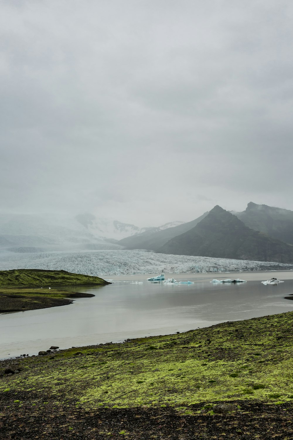 body of water surrounded gray mountains photography