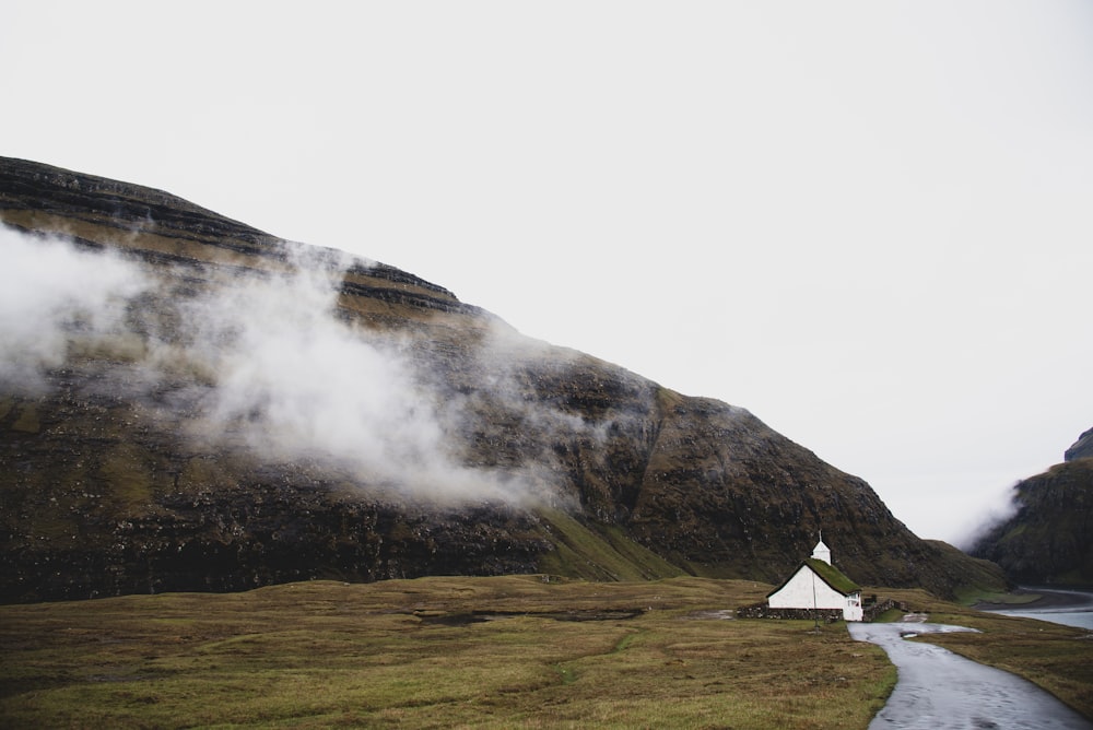 brown mountain near white clouds