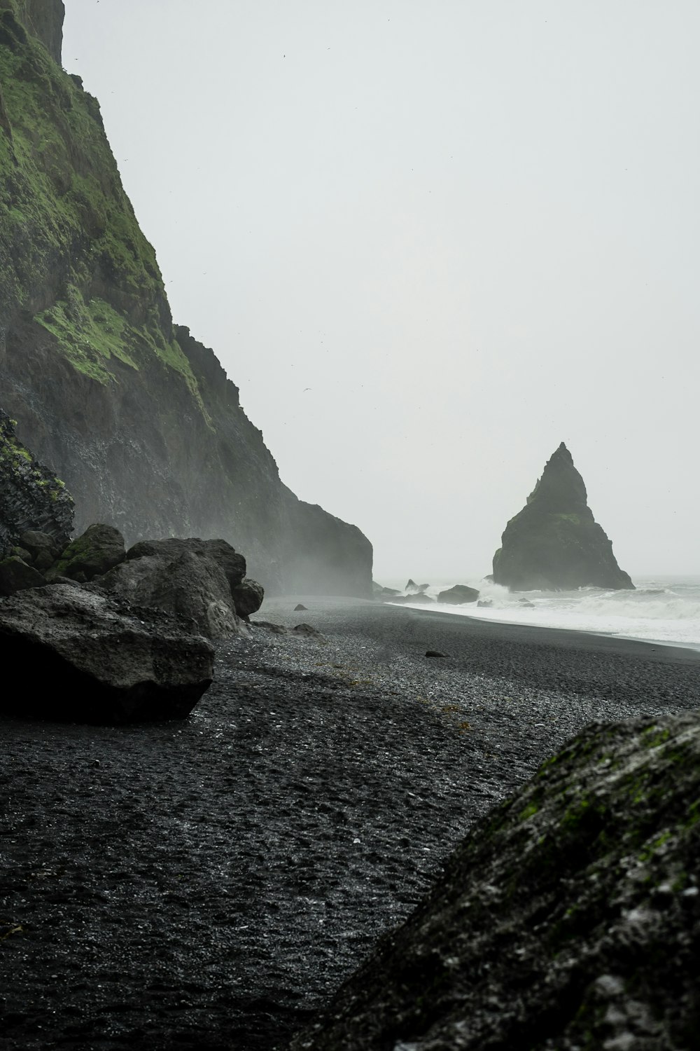 해변 근처 수역에 있는 검은 암석의 풍경 사진