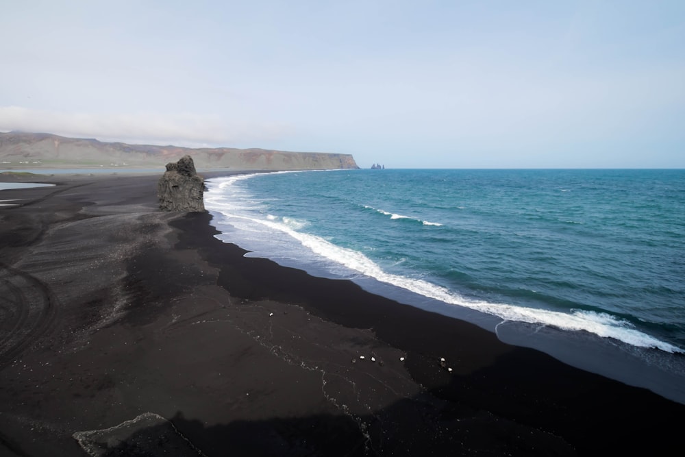 aerial view of black sand beach under clear skies