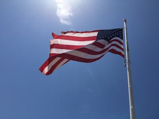 low-angle photography of US flag under clear blue sky