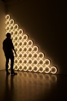silhouette photo of man standing in front of LED wall lights \