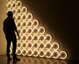 silhouette photo of man standing in front of LED wall lights \