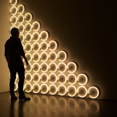 silhouette photo of man standing in front of LED wall lights \