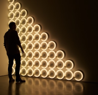 silhouette photo of man standing in front of LED wall lights \