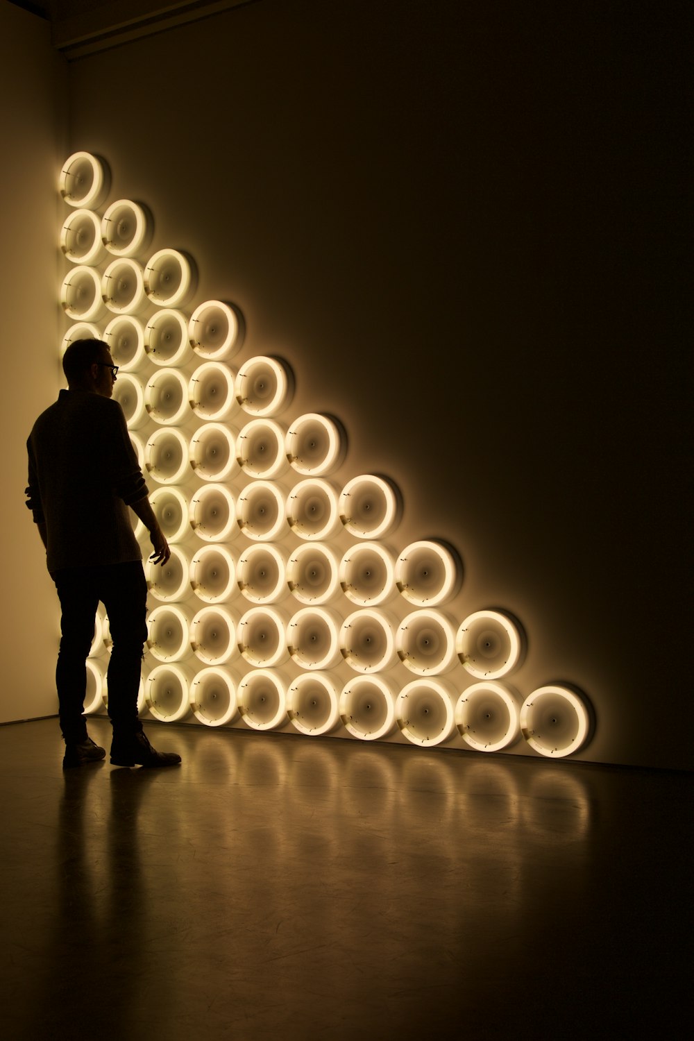 silhouette photo of man standing in front of LED wall lights \