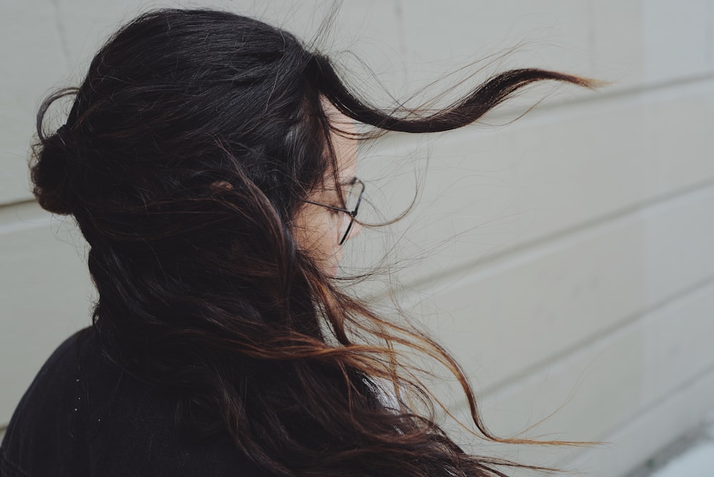 woman near white wall getting her hair blown