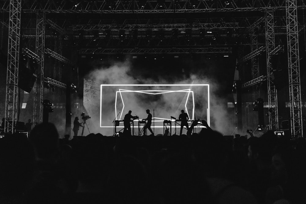 silhouette photo of rock band on stage performing in front of audience