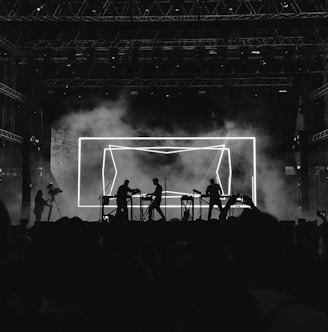 silhouette photo of rock band on stage performing in front of audience