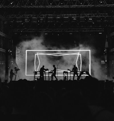 silhouette photo of rock band on stage performing in front of audience