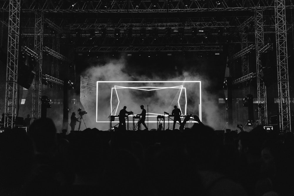 foto di silhouette di rock band sul palco che si esibisce di fronte al pubblico