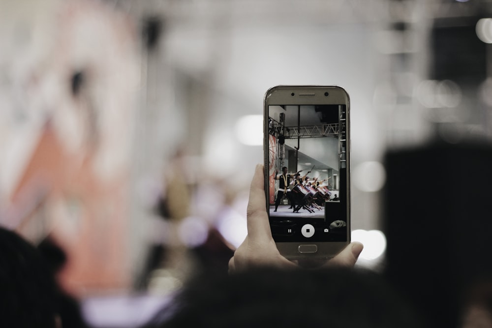 Photographie sélective de mise au point d’une personne à l’aide d’un smartphone argenté