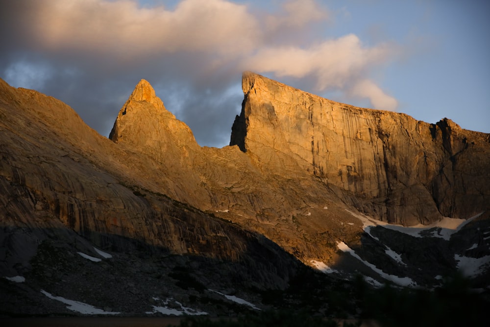 brown rocky mountain under cloudy sky during daytime