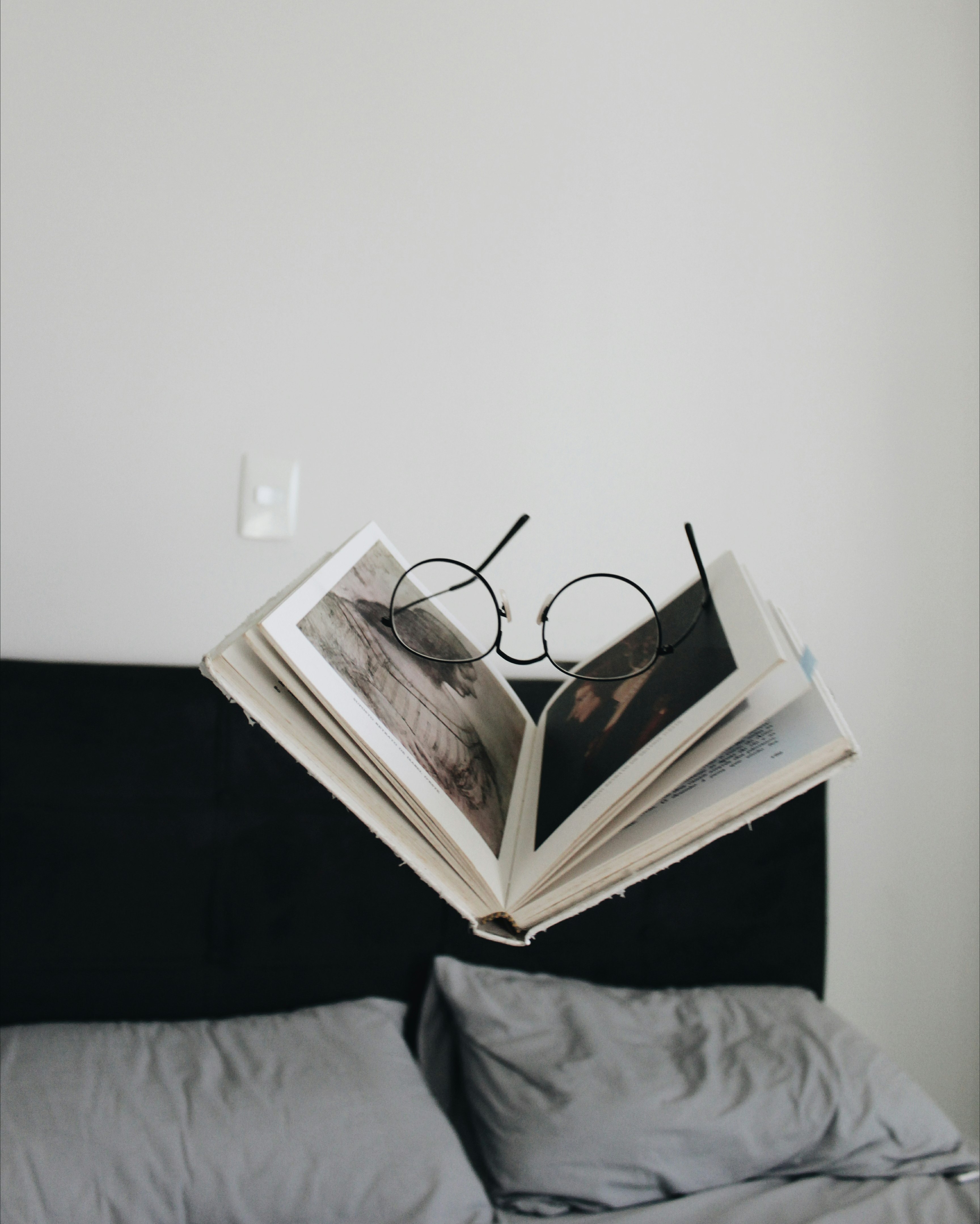 black framed eyeglasses between opened book