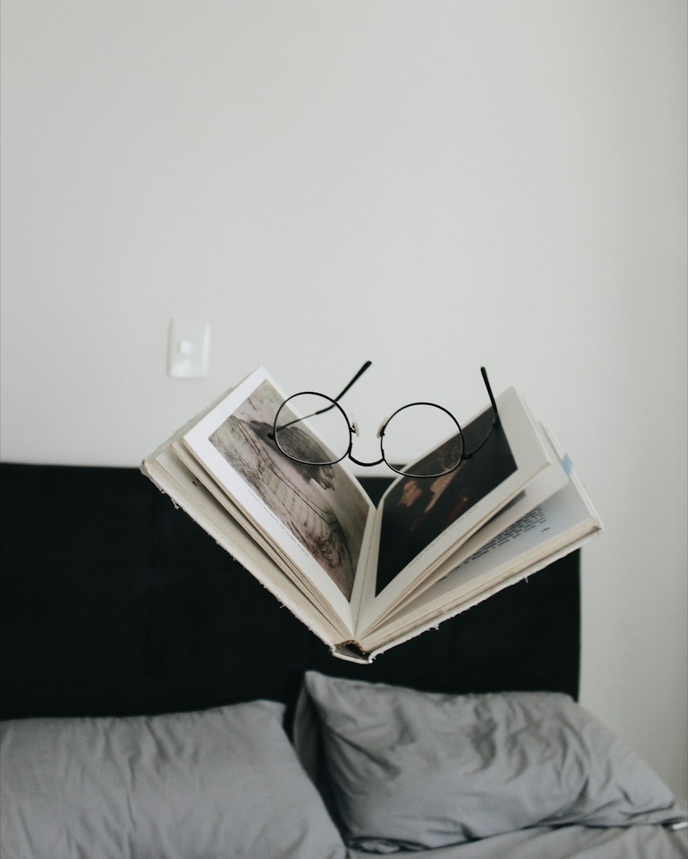 black framed eyeglasses between opened book