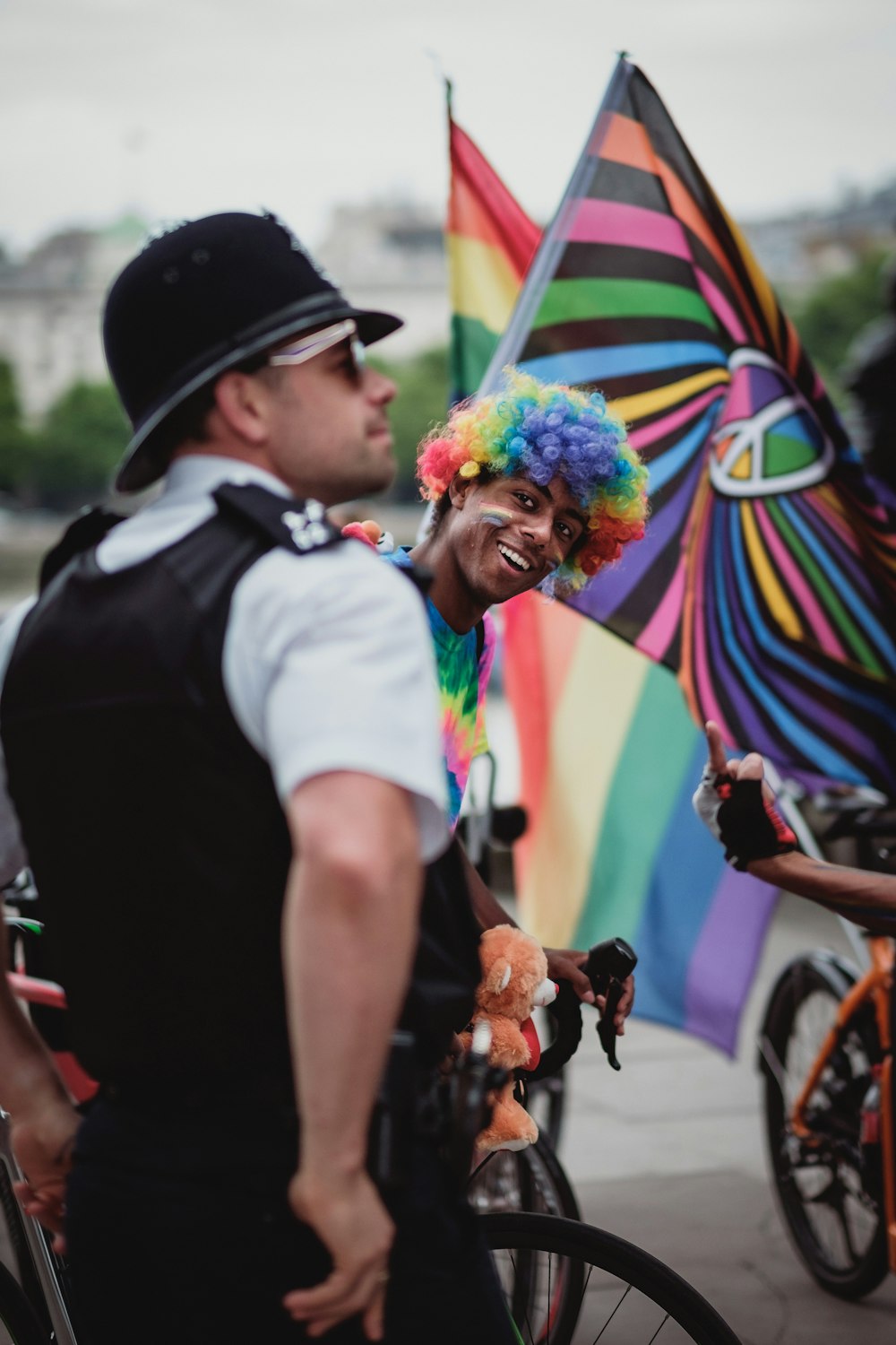 person wearing rainbow wig riding bicycle