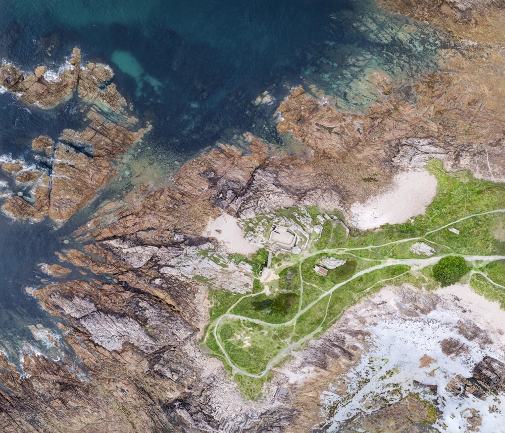 aerial view of green grass near body of water during daytime