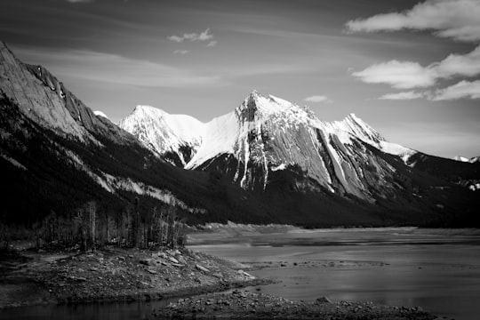 snow filled mountain beside body of water in Jasper National Park Of Canada Canada