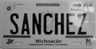 A black and white license plate from Michoacán, Mexico, displaying the name 'SANCHEZ' in bold letters. The plate includes a map outline of the region and text reading 'Transporte Privado Automovil'. Various official symbols and serial numbers are visible.