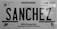 A black and white license plate from Michoacán, Mexico, displaying the name 'SANCHEZ' in bold letters. The plate includes a map outline of the region and text reading 'Transporte Privado Automovil'. Various official symbols and serial numbers are visible.