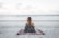 woman sitting on blanket located on shoreline
