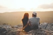 man and woman sitting on rock during daytime