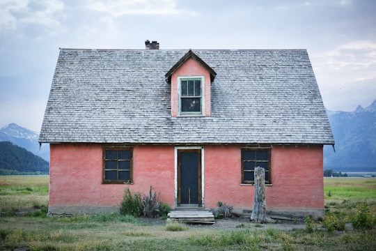red and gray brick house under gray sky in Mormon Row United States