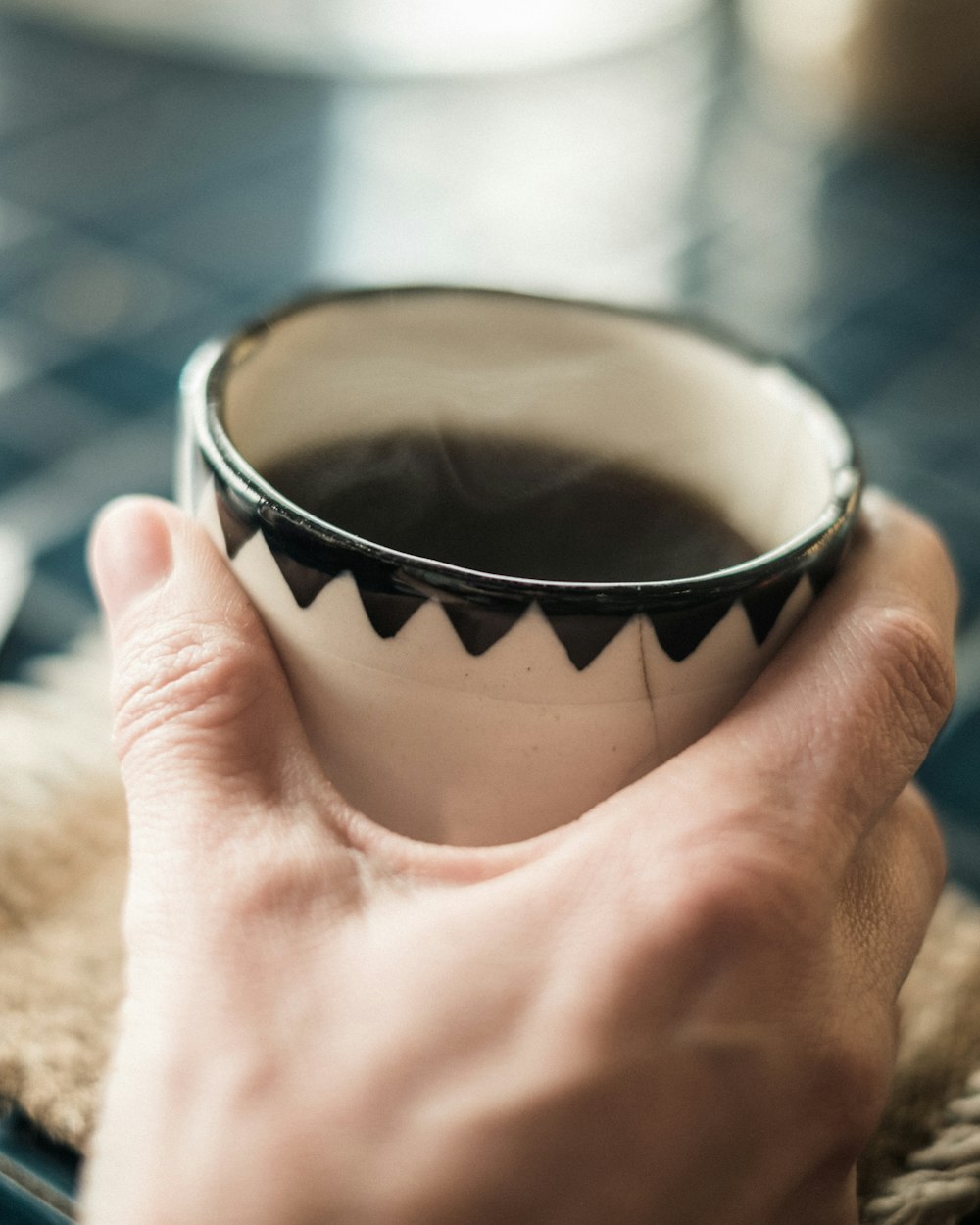 person holding white ceramic teacup