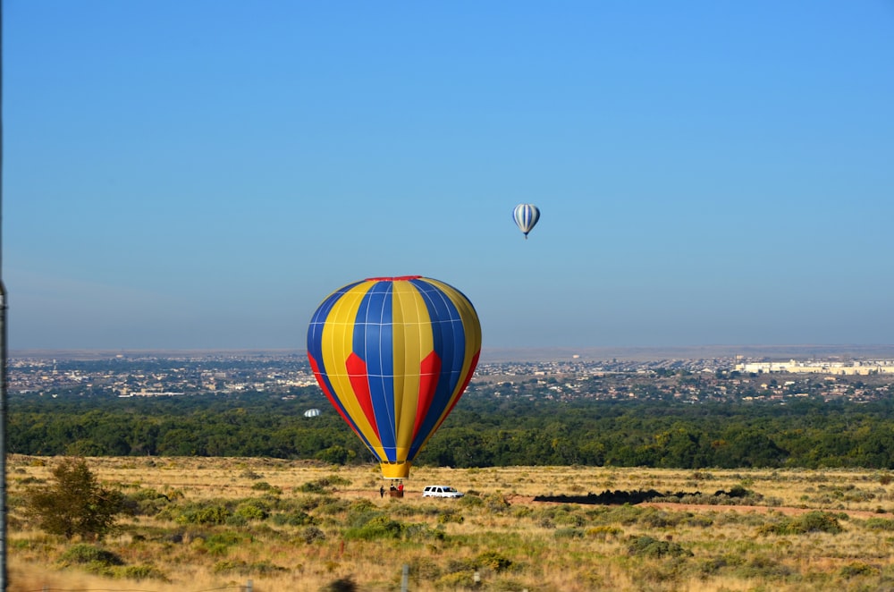 Dos globos aerostáticos sobre tierra beige