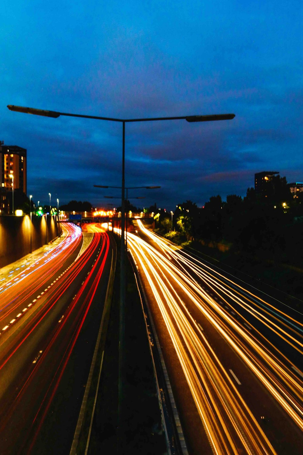 Fotografia time lapse di auto di passaggio su strada durante la notte