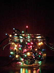A storage jar filled with neatly packed holiday lights.
