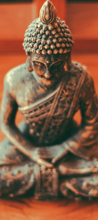 Gautama Buddha figurine on brown wooden surface
