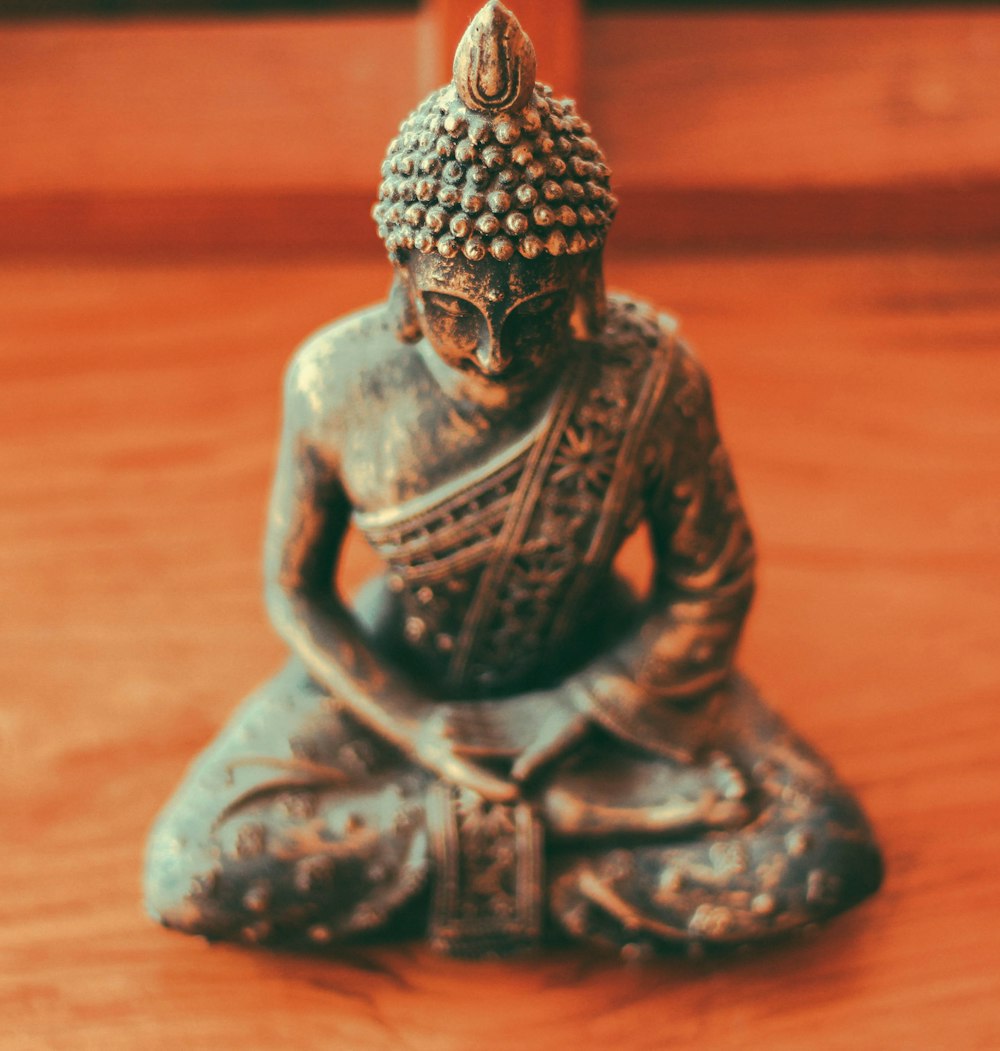 Gautama Buddha figurine on brown wooden surface